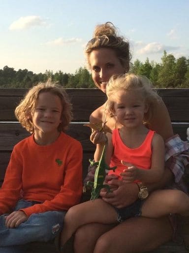 Elisabeth at sunset on a hayride with a boy in an orange sweater and a toddler holding a toy lizard